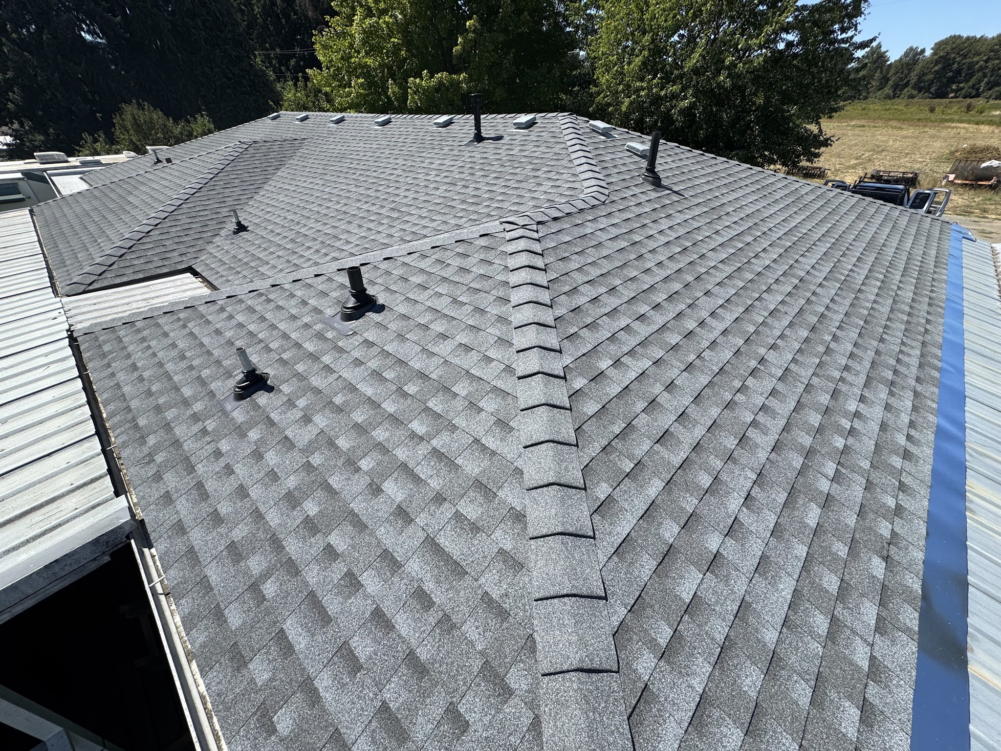 Finished shingle roof with new ridge vents and clean flashing details