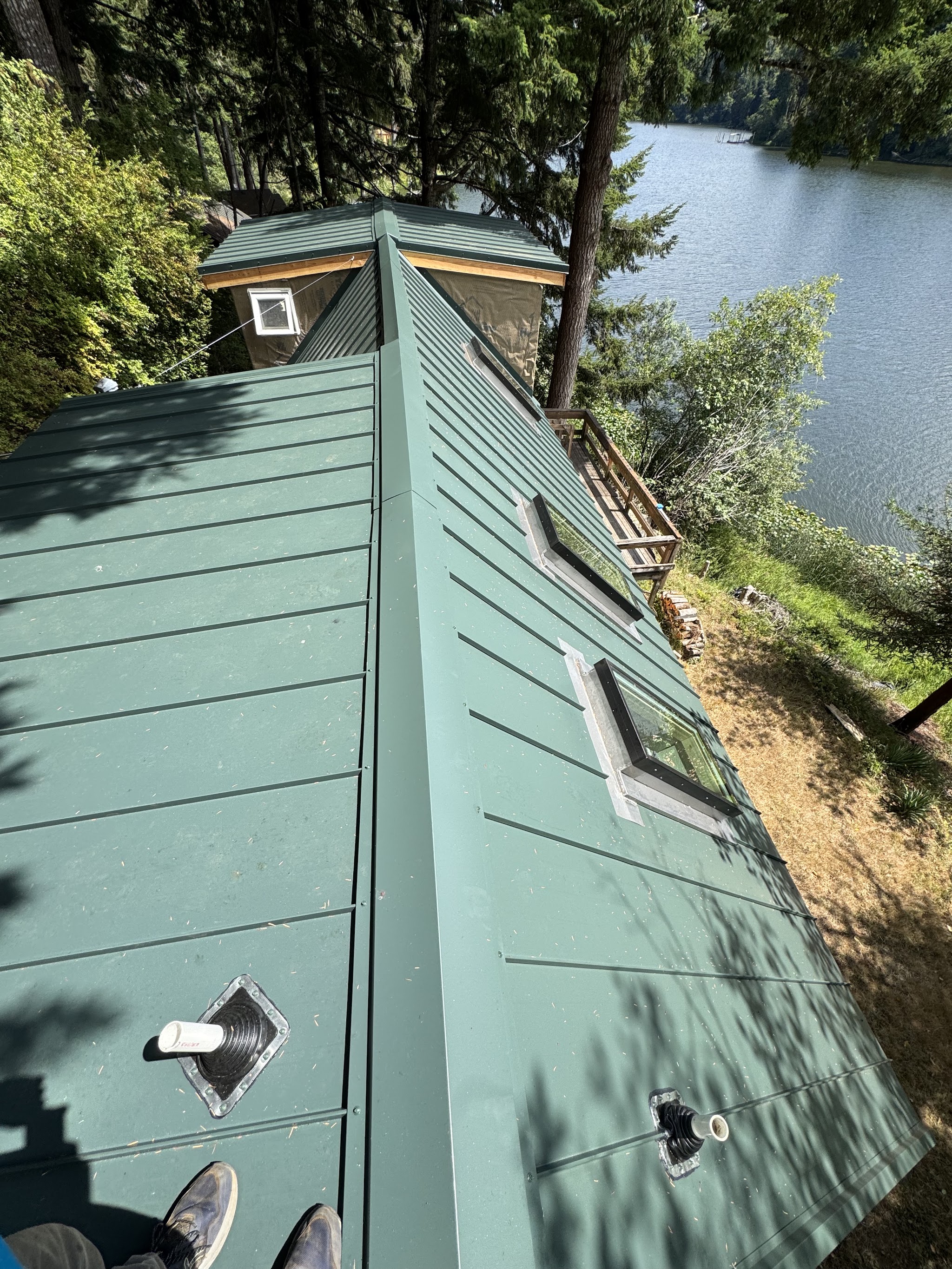 Standing-seam metal roof panels installed along a lakeside property