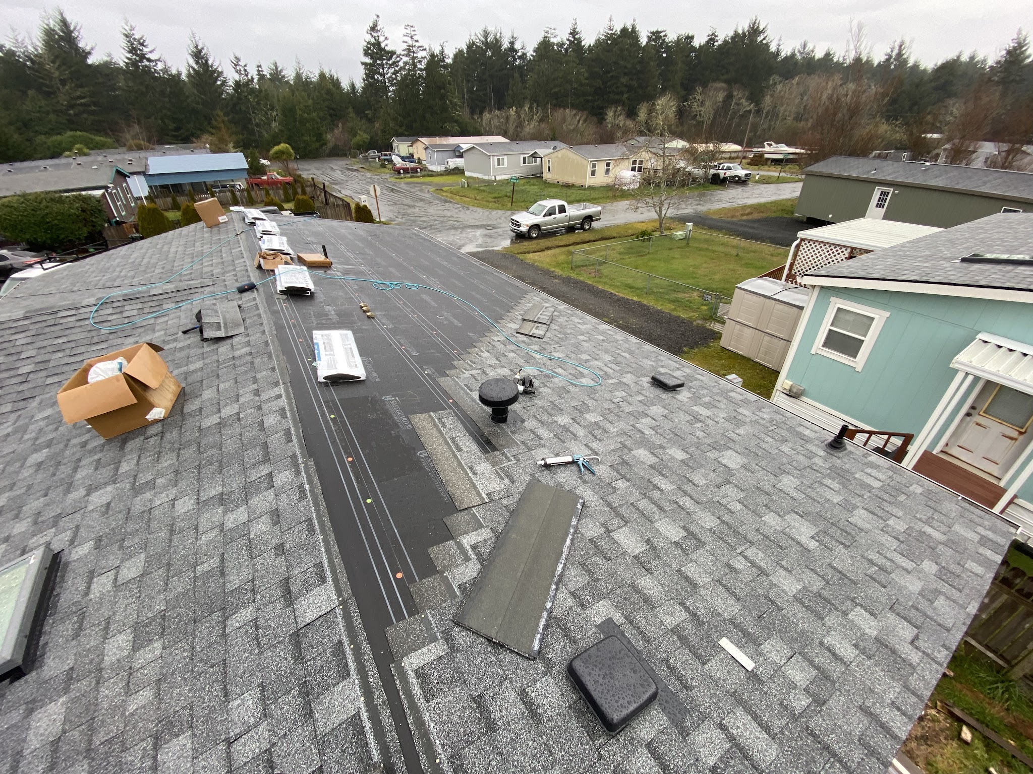 Roof tear-off in progress on an overcast day in a Roseburg neighborhood
